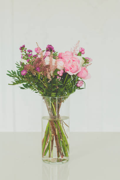 istock Pink flowers in glass vase on white background 1317676245