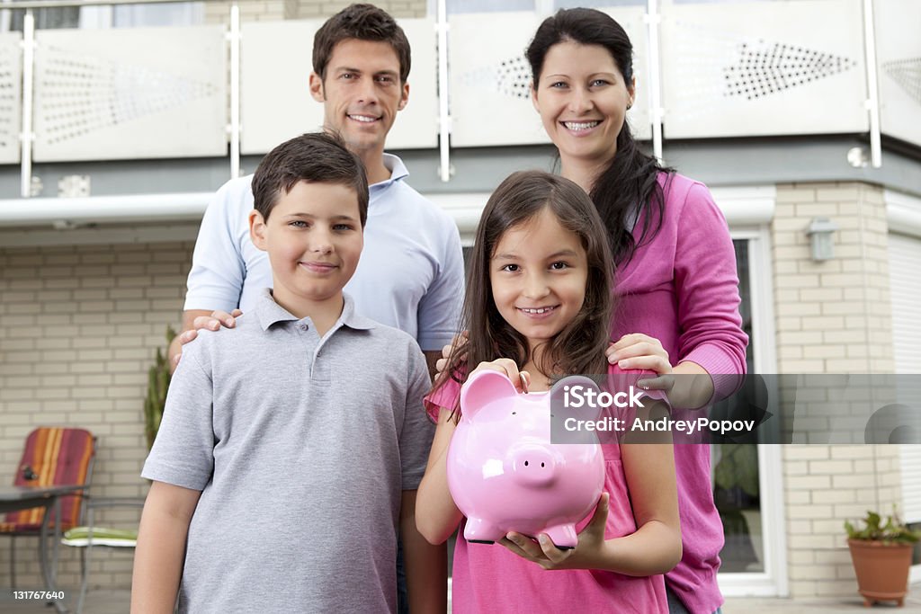 Kleines Mädchen mit Ihrer Familie holding ein Sparschwein - Lizenzfrei Beide Elternteile Stock-Foto