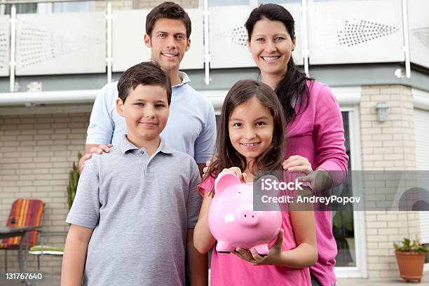 Kleines Mädchen Mit Ihrer Familie Holding Ein Sparschwein Stockfoto und mehr Bilder von Beide Elternteile