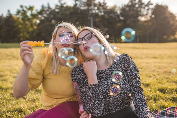 istock Sisters having fun making soap balloons in the park 1317677049
