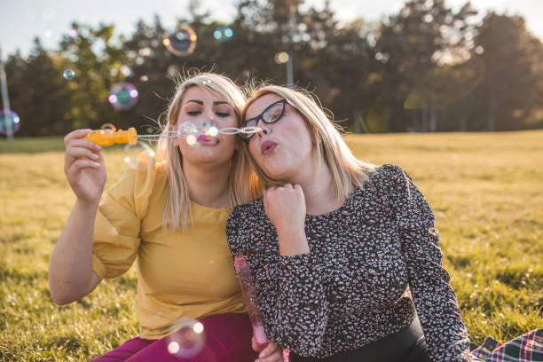 istock Friends having fun making soap bubbles on picnic 1317678867