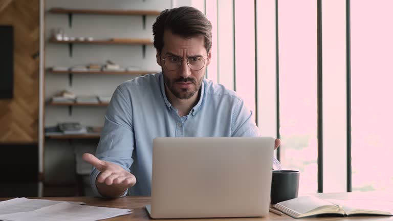 Businessman looks at laptop screen angry by system unexpected error