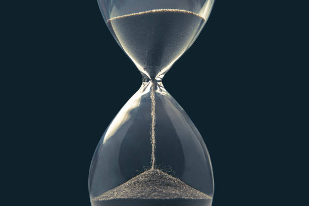 istock Hourglass on a dark background. Time is money. Business solutions in time. 1317686061
