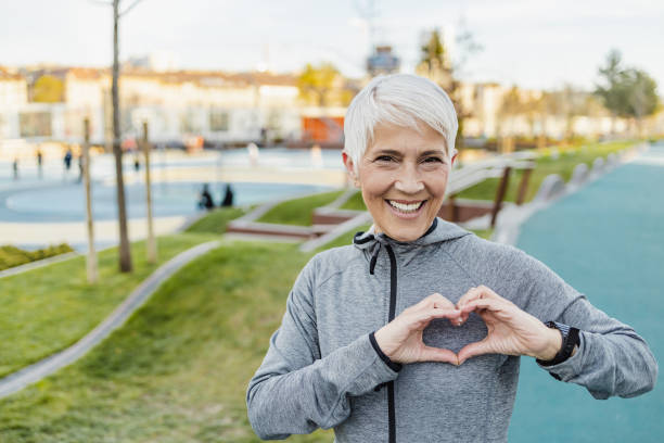 istock Smiling senior woman making a heart sign with her hands 1317687276