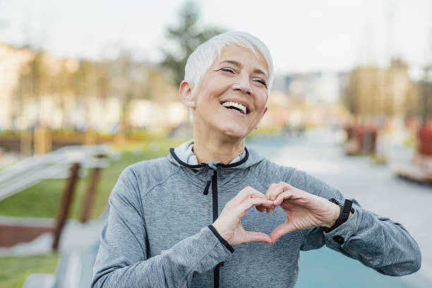 istock Smiling senior woman making a heart sign with her hands 1317687329