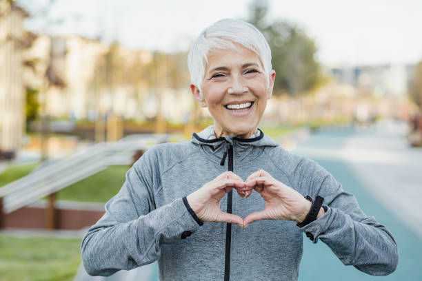 istock Smiling senior woman making a heart sign with her hands 1317687961