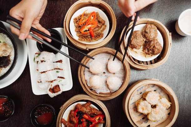 Dim sun time Bird's eye view looking down at a table with Chinese dim sum. First-person perspective of food on a table at a restaurant. asian food stock pictures, royalty-free photos & images