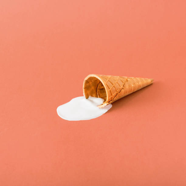 istock A cone with melted ice cream on a bright red background. Minimalistic summer food concept 1317688259