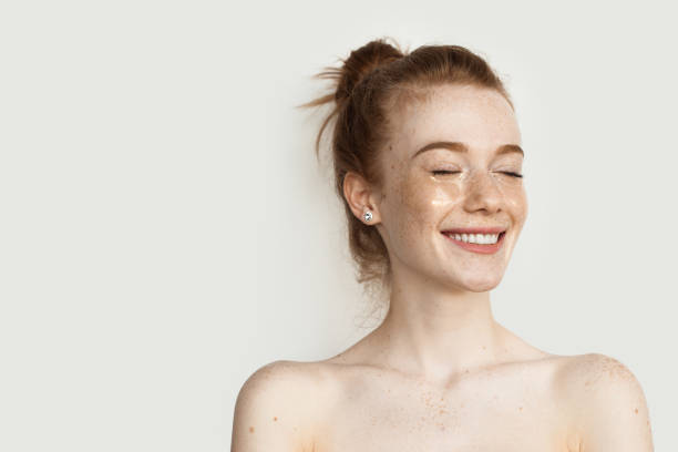istock Ginger woman with eye patches is smiling on a studio wall with bare shoulders 1317688476