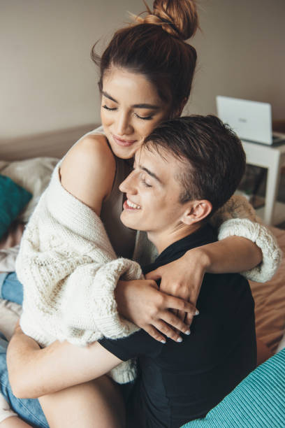 istock Cute woman embracing her lover is smiling while cheering in bed with him 1317688501