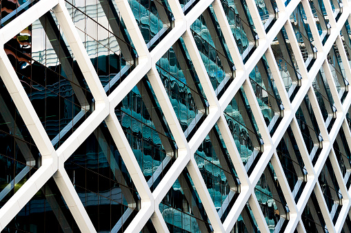 Closeup modern office building glass wall with reflection, abstract background with copy space, full frame horizontal composition