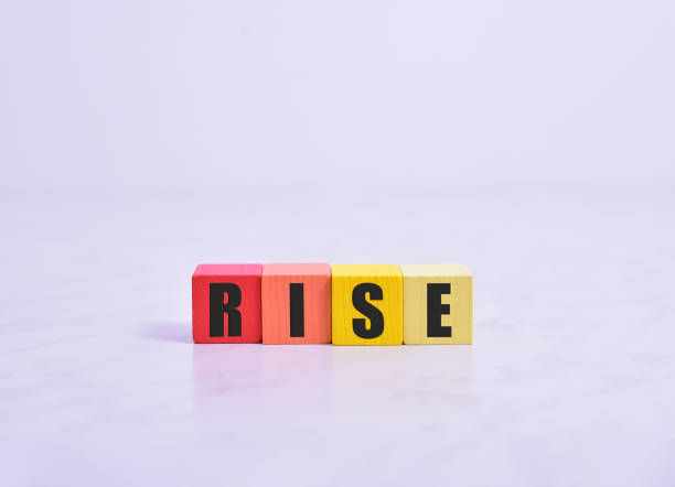 istock Wooden cubes with letters on a white table. The word is RISES. White background 1317690177