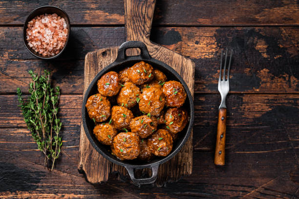 istock Meatballs in tomato sauce from beef and pork meat with thyme in rustic pan. Dark background. Top view 1317691271