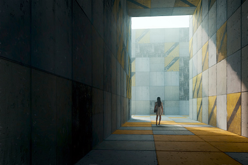 Lonely woman walking in concrete city corridor. Entirely 3D generated image.