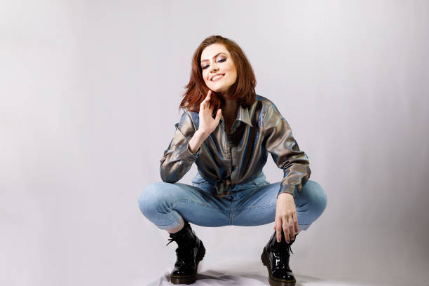 view of a woaman sitting on her haunches looking up on white background