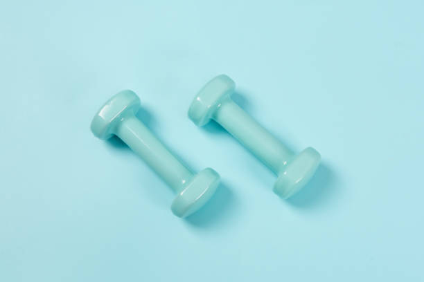 istock Two blue dumbbells isolated on blue background 1317707751