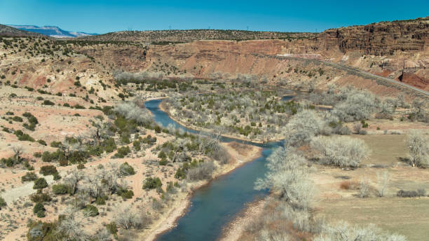 fiume e strada nel red wash canyon, nuovo messico - new mexico landscape arid climate plateau foto e immagini stock