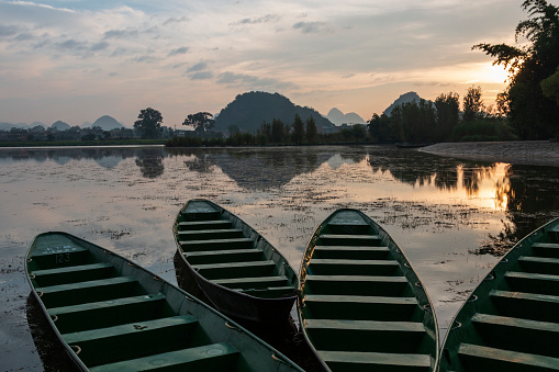 Wooden boats at sunrise in Puzhehei - Yunnan, China