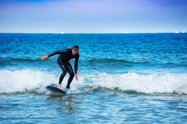 istock Man learns to surf surfboard on small waves in sea 1317711649