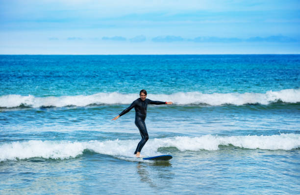istock Man ride the surfboard on small waves learn surf 1317711656