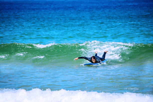 istock Man paddling in the sea to catch wave on surfboard 1317711676
