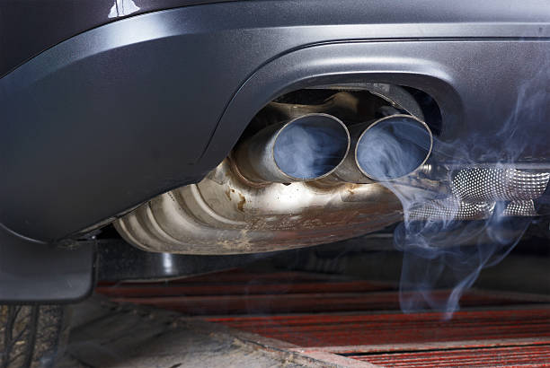 Exhaust pipe of a car - blowing out the pollution. Exhaust pipe of a car - blowing out the pollution. Exhaust pipe coming out of the car with its exhaust. View from below, see the bottom of the exhaust pipe silver. Visible rear bumper eclipse of gray. exhaust pipe photos stock pictures, royalty-free photos & images
