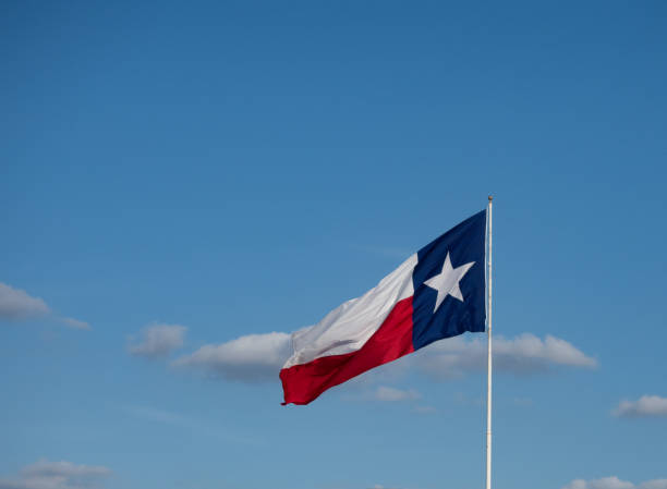 istock Horizontal Unfurled Texas Lone Star Flag with Clouds in the Background 1317716421