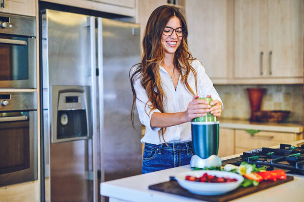 Shot of a young woman making a healthy smoothie at home What you consume determines how you feel blender photos stock pictures, royalty-free photos & images