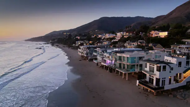 Aerial drone still from above the coastline in Malibu, California at sunset.