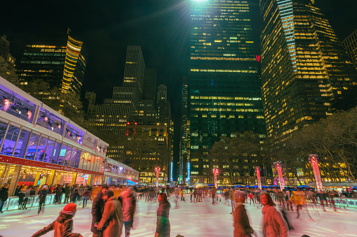 bryant park new york,United States Nov 30 2019:People are enjoying Ice Skating at Bryant Park New York in dusk at Christmas Holidays Season during the winter. Local vendors also set up market stalls in the park during the winter.