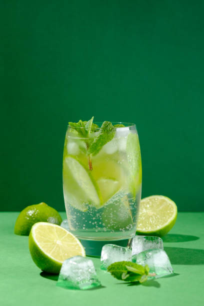 istock Refreshing summer cocktail mojito, fresh mint, lime and ice with hard light on green background. Copy space. 1317728271