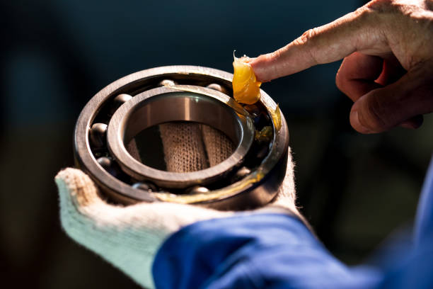 fermez-vous vers le haut de la graisse de lubrifiant dans la main mécanicien pour mettre dans le roulement de boule dans l’usine industrielle, concept industriel de mécanicien - endurance photos et images de collection