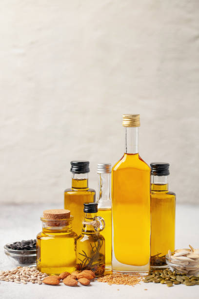 istock Various vegetable and nut oil in bottles on a bright background. 1317729346