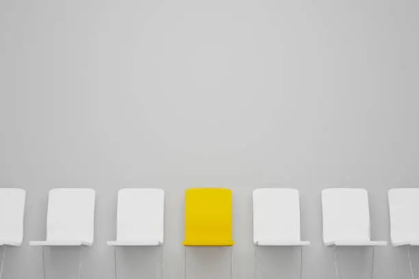 Photo of Outstanding chair in row. Yellow chair standing out from the crowd. Human resource management and recruitment business concept. 3d illustration