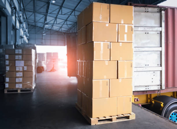 istock Stack of Package Boxes Load into Container Truck. Truck Parked Loading at Dock Warehouse. Delivery Service. Shipping Warehouse Logistics. Shipment Freight Truck Transportation. 1317731977