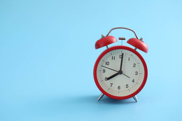 istock Red retro alarm clock isolated on a blue background 1317733401