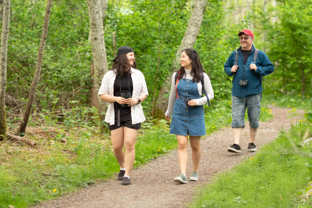Eurasian Sisters and Father Enjoying Walk Through Woods with Binoculars