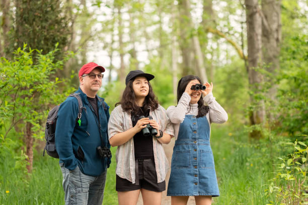 istock Father and Daughters Birdwatching in Forest with Binoculars 1317734580