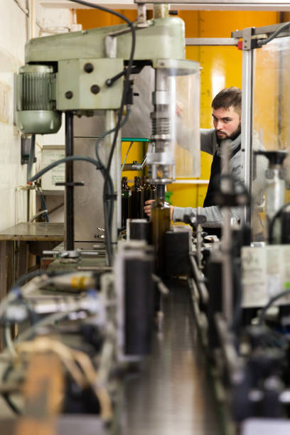 istock Young man working on olive oil bottling line 1317734700