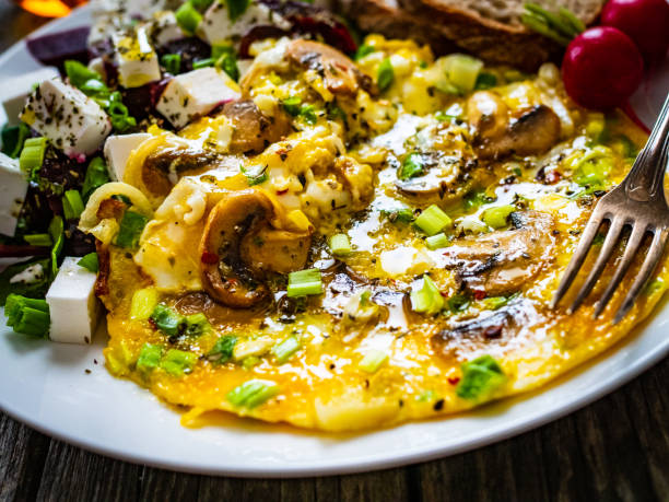 istock Continental breakfast -  scrambled eggs with mushrooms, feta cheese and fresh vegetables on wooden table 1317738114