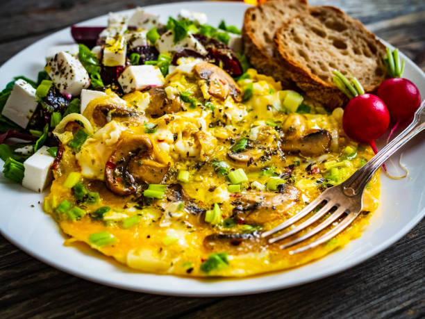 istock Continental breakfast -  scrambled eggs with mushrooms, feta cheese and fresh vegetables on wooden table 1317738140