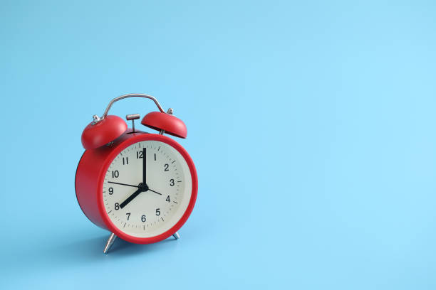istock Red retro alarm clock isolated on a blue background 1317742167
