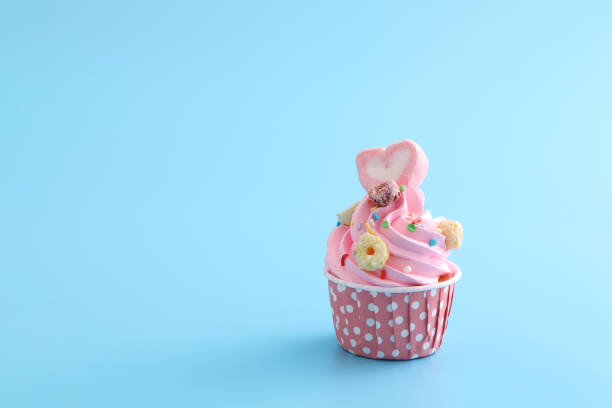 istock pink cupcake isolated in blue background 1317742178