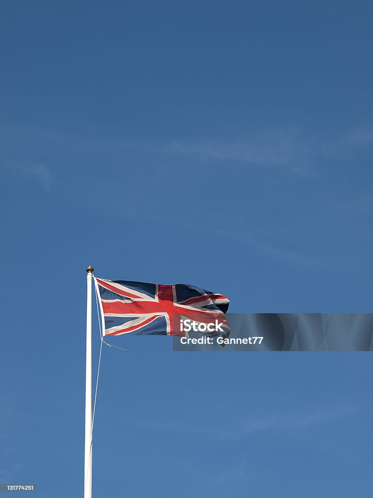 Union Jack flying przed błękitne niebo - Zbiór zdjęć royalty-free (Anglia)