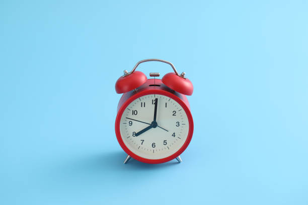 istock Red retro alarm clock isolated on a blue background 1317742524