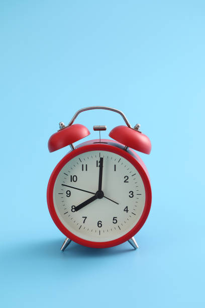 istock Red retro alarm clock isolated on a blue background 1317742570