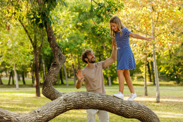 istock A Young Father is Playing on a Branch with his Daughter in Nature. 1317744567