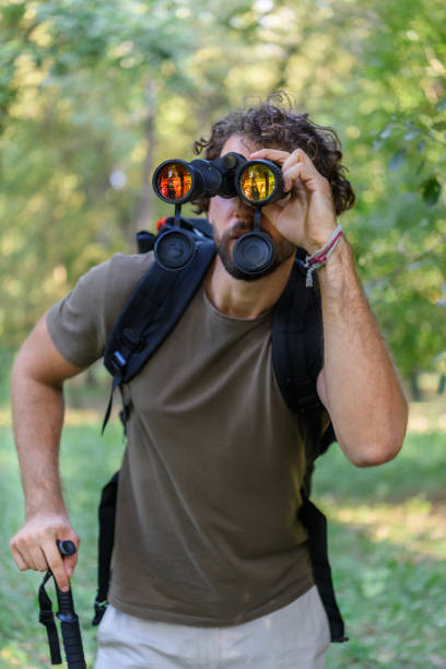 istock Young Man is Hiking in Forest in Nature and Using Binoculars. 1317745316