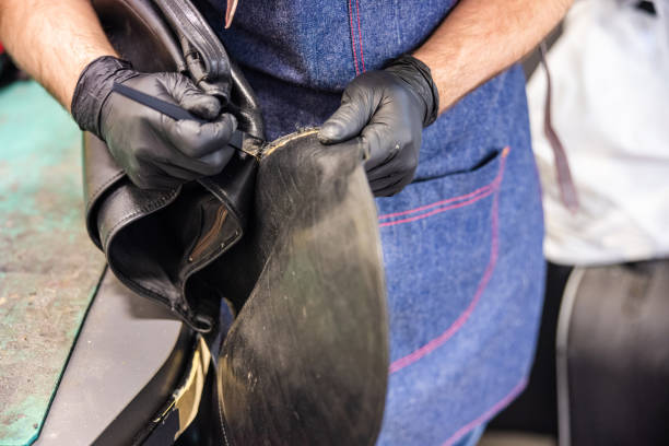 istock Wearing protective gloves and using chisel in repairing leather item 1317746962