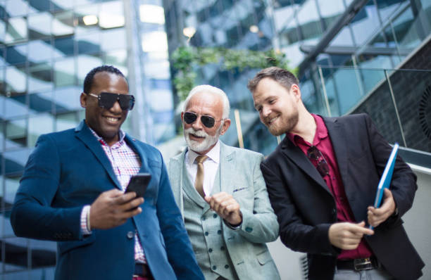 istock Three business men walking and talking outside. Man holding mobile 1317748329